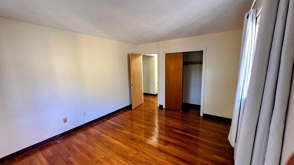 8 Riverside Street, Unit 13 Watertown, MA 02472 - Photo 16 of 18 a view of an empty room with wooden floor and a window