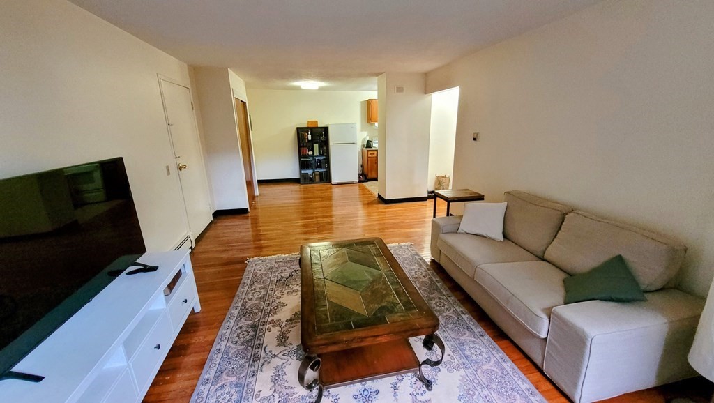 8 Riverside Street, Unit 13 Watertown, MA 02472 - Photo 6 of 18 a living room with furniture and a flat screen tv