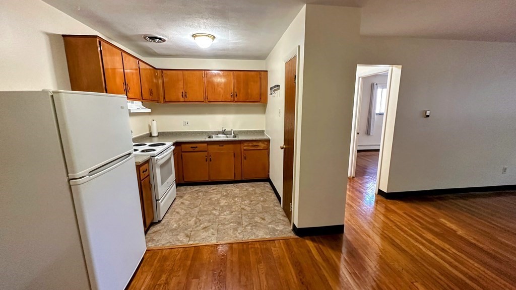 8 Riverside Street, Unit 13 Watertown, MA 02472 - Photo 8 of 18 a kitchen with stainless steel appliances granite countertop a refrigerator a stove and a sink