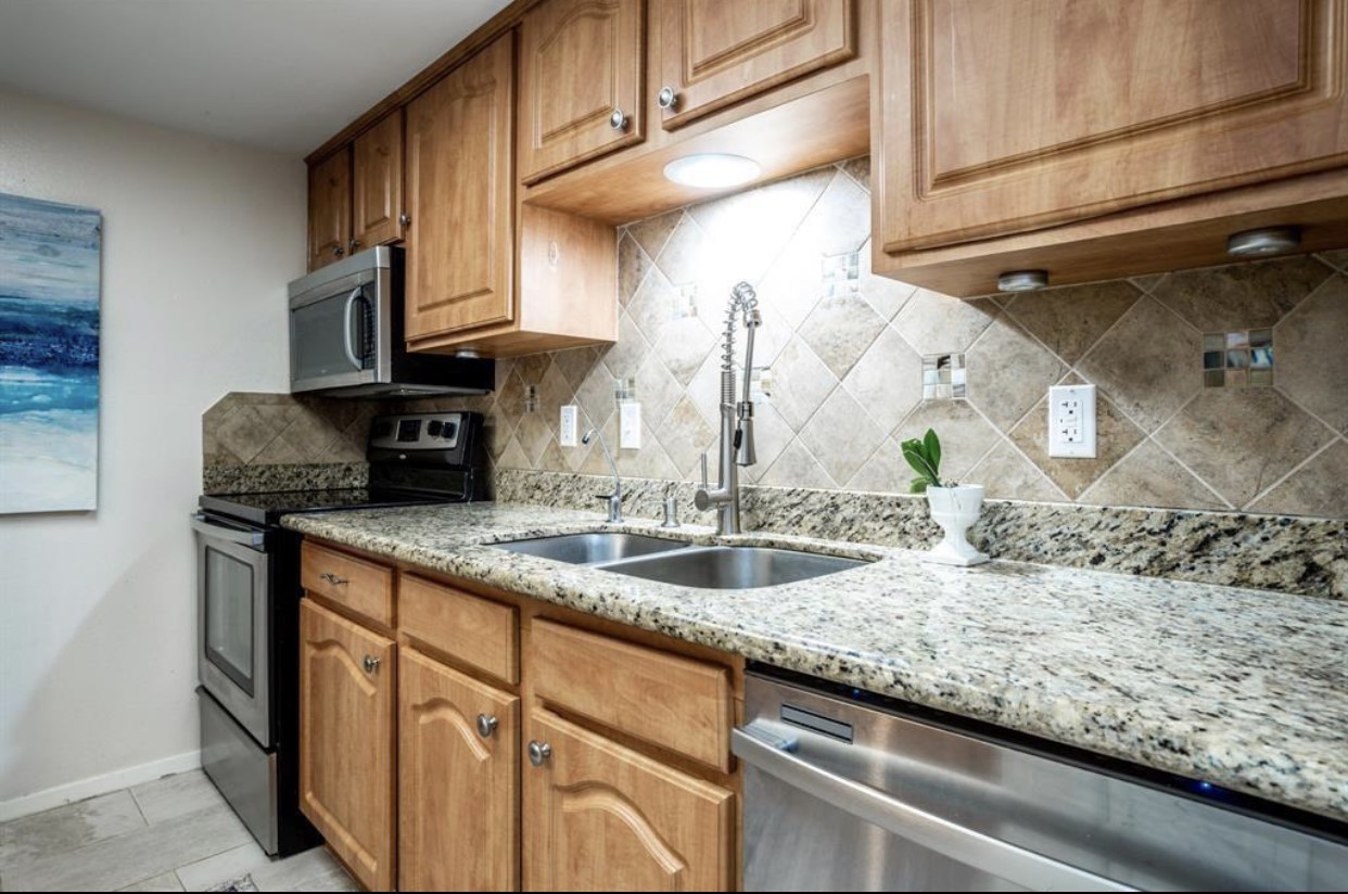 2228 South Piney Point Road, Unit 101 Houston, TX 77063 - Photo 5 of 8 a kitchen with granite countertop a sink and a stove
