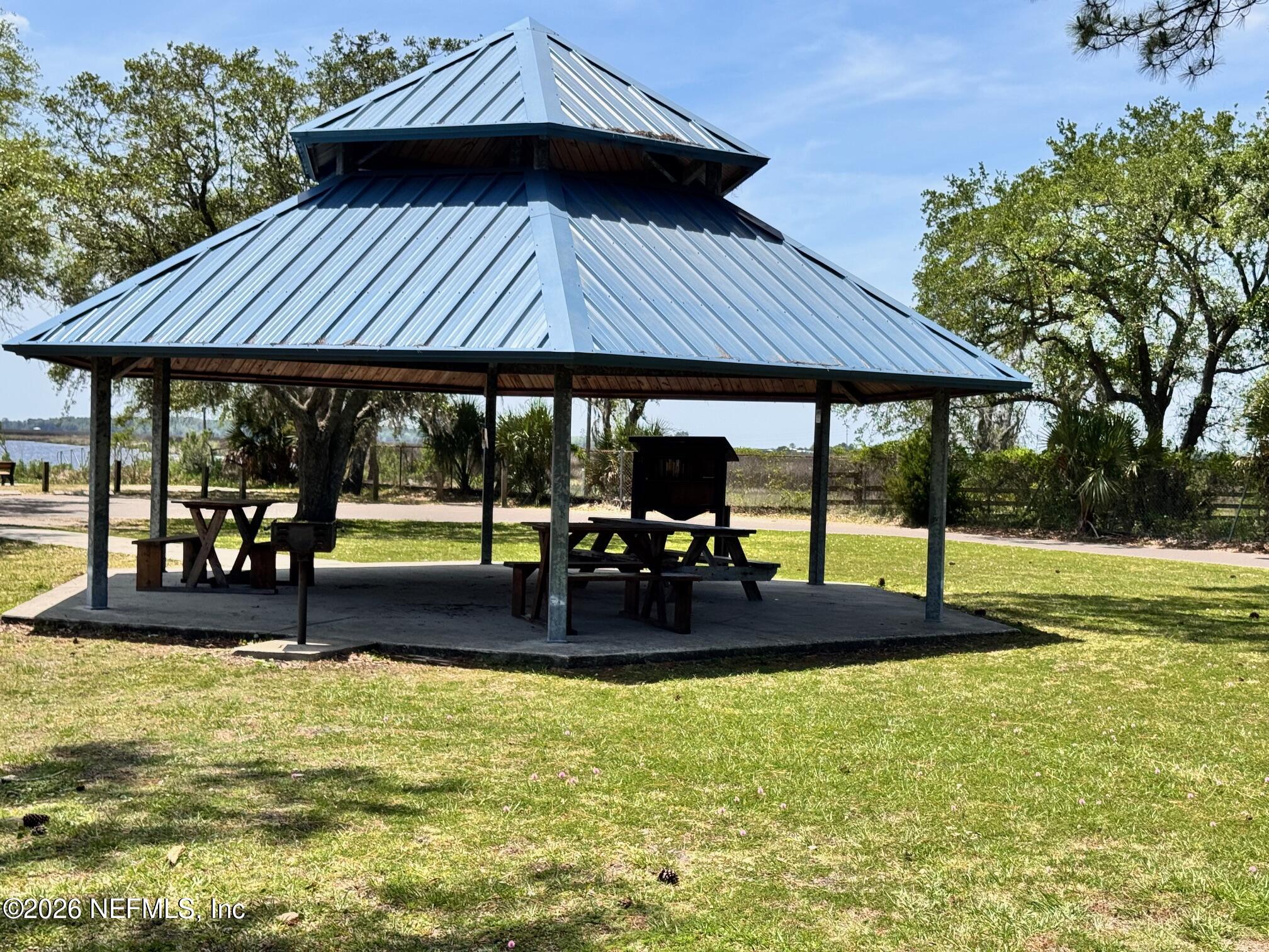 1293 Claxton Road Yulee, FL 32097 - Photo 18 of 19 a view of pool with lawn chairs under an umbrella
