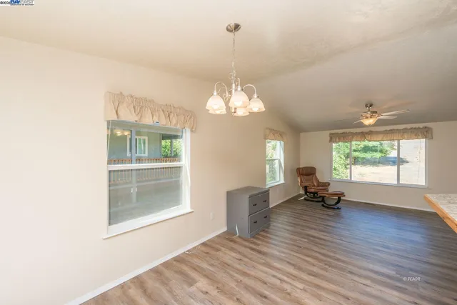 a view of a room with wooden floor potted plant and windows
