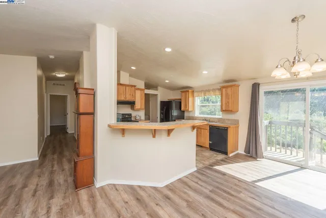 a kitchen with stainless steel appliances kitchen island hardwood floor sink stove and granite counter top