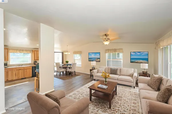a living room with furniture ceiling fan and a window