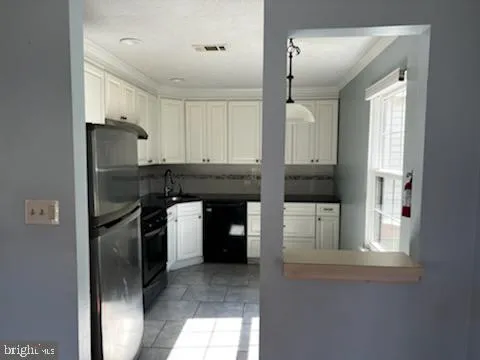 a kitchen with a refrigerator and a sink