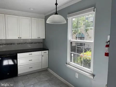 a kitchen with granite countertop white cabinets and a window