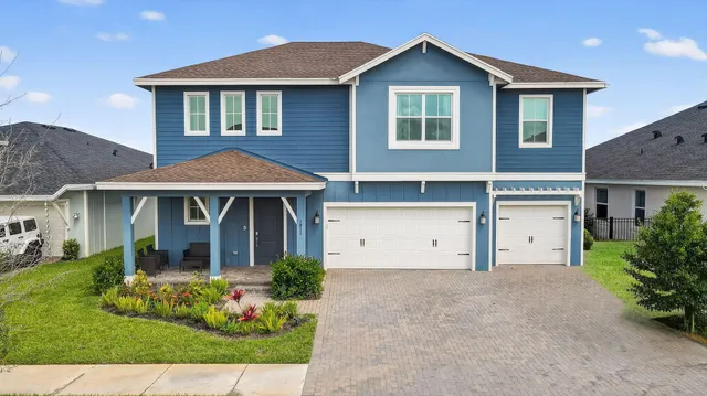 a front view of a house with a garden and plants