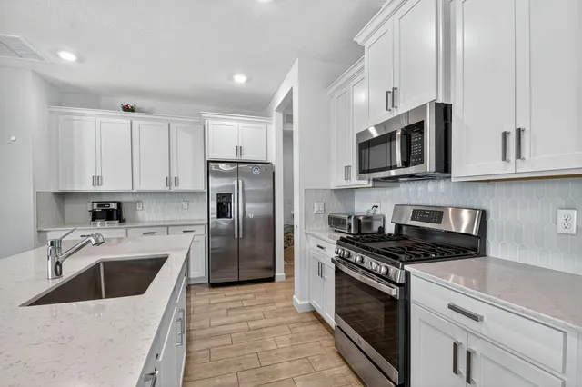 a bathroom with a granite countertop sink a mirror and shower