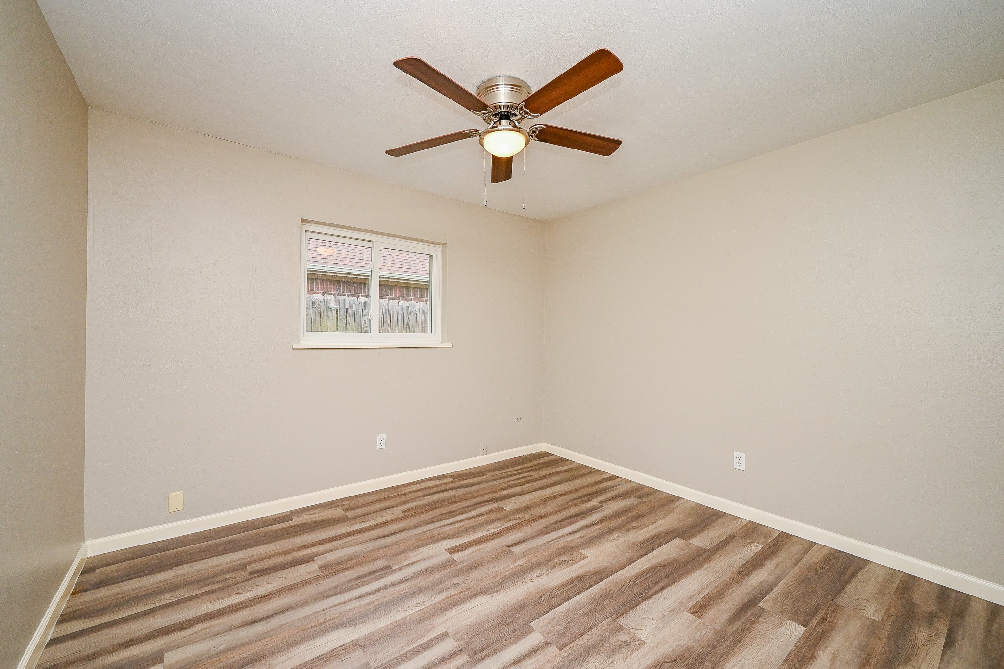 18318 Navajo Trail Drive Spring, TX 77388 - Photo 13 of 16 Secondary bedroom with ceiling fan, window, and updated flooring.