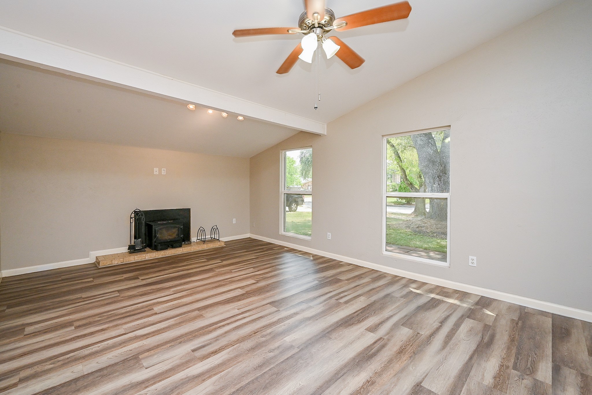 18318 Navajo Trail Drive Spring, TX 77388 - Photo 3 of 16 Spacious living room with updated flooring, ceiling fan, and a wood-burning fireplace.
