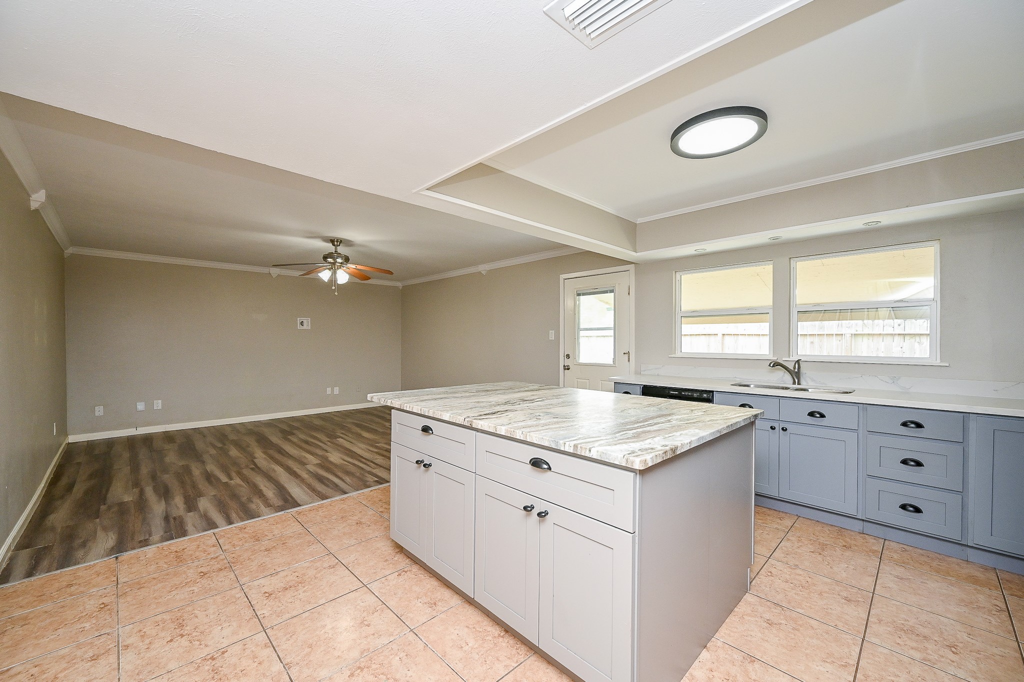 18318 Navajo Trail Drive Spring, TX 77388 - Photo 6 of 16 View from kitchen into den with ceiling fan and updated flooring, creating an open-concept feel.