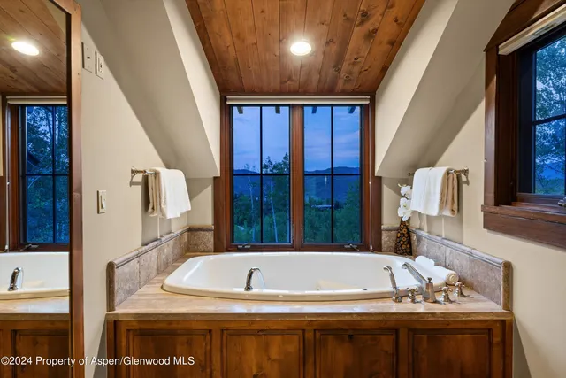 a view of en suite bathroom with a tub and window