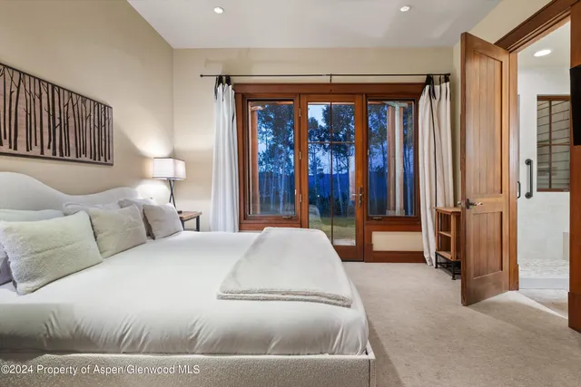 a spacious bedroom with a large bed and a large window