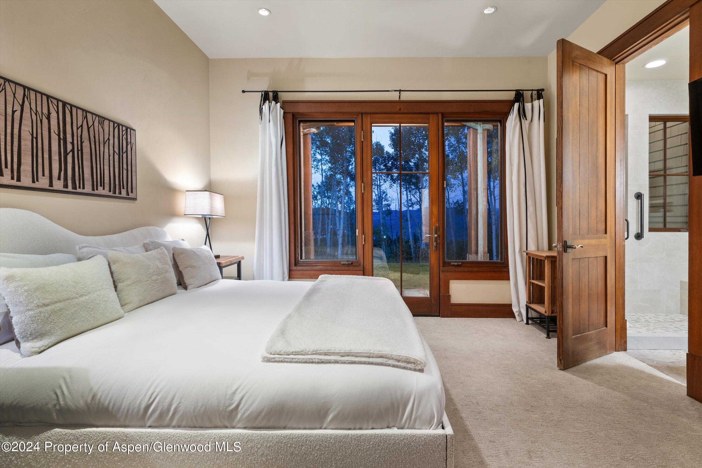 1021 Two Creeks Drive Snowmass Village, CO 81615 - Photo 26 of 47 a spacious bedroom with a large bed and a large window