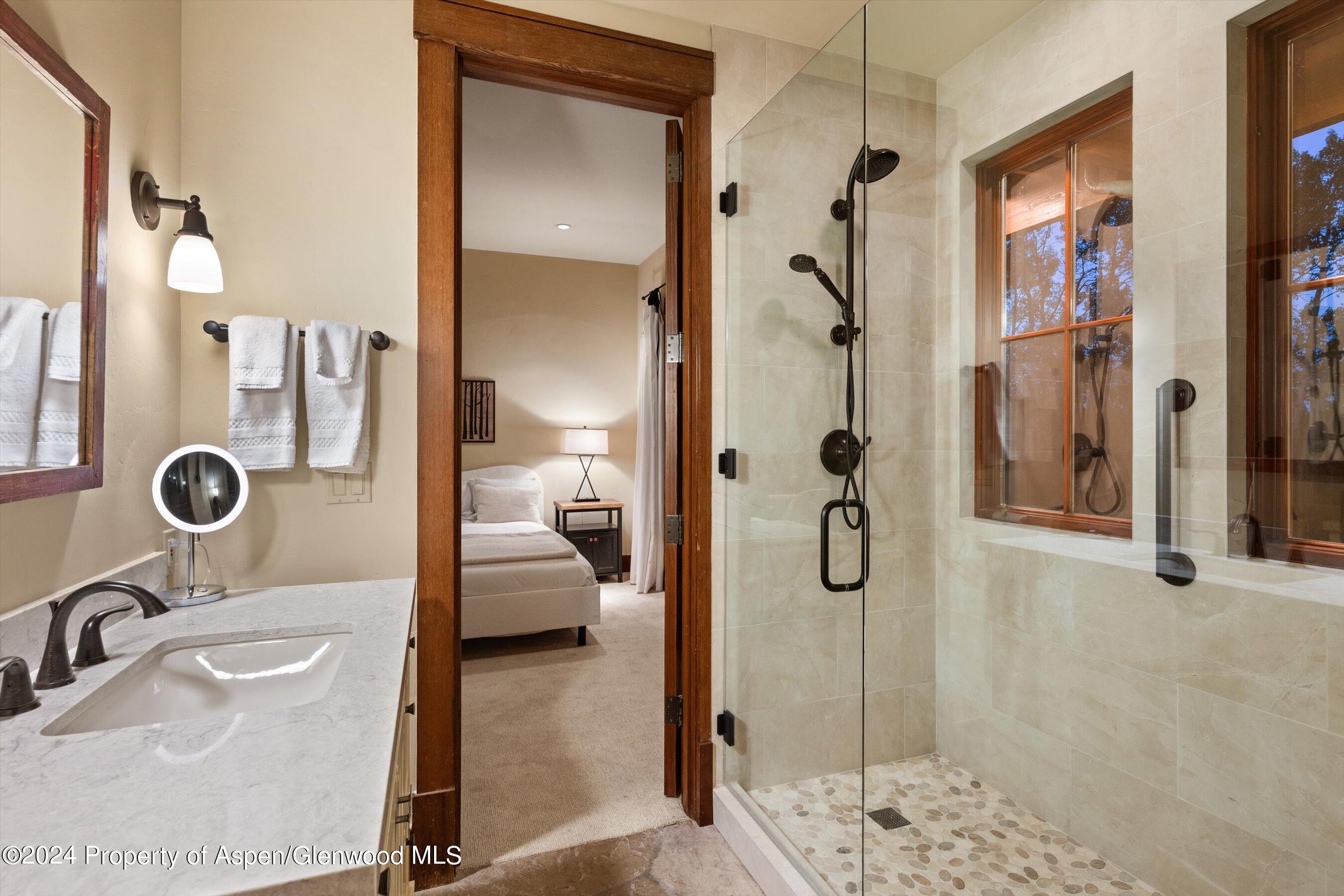 1021 Two Creeks Drive Snowmass Village, CO 81615 - Photo 28 of 47 a bathroom with a granite countertop shower mirror and vanity