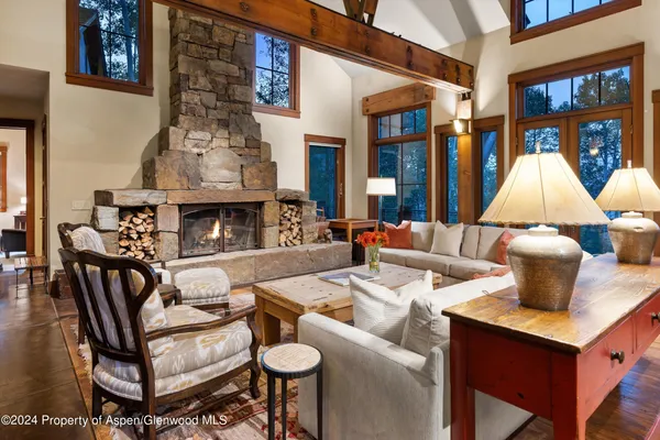 a living room with furniture a fireplace and a large window