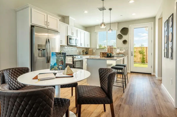 a kitchen with stainless steel appliances kitchen island granite countertop a kitchen island a stove a table and chairs