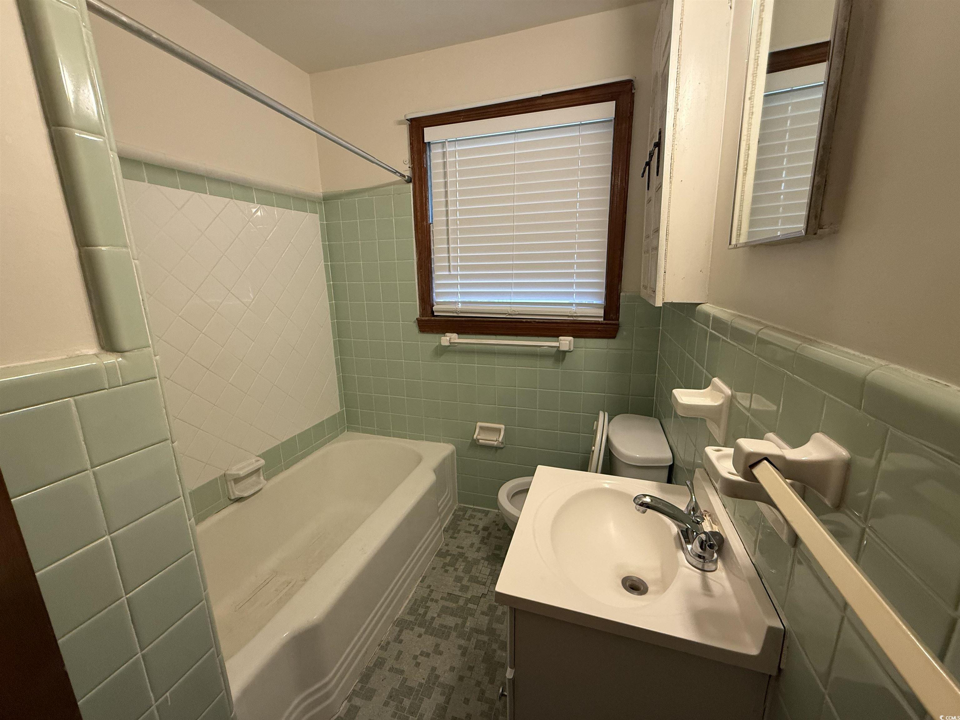 1208 Richmond Drive Georgetown, SC 29440 - Photo 7 of 9 Bathroom with tile walls, a wainscoted wall, toile