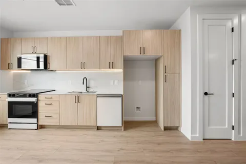 a kitchen with white cabinets and stainless steel appliances