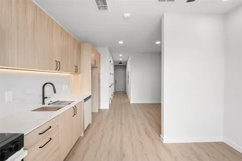 a view of a kitchen with a sink and wooden floor