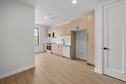 a view of a kitchen with wooden floor and electronic appliances