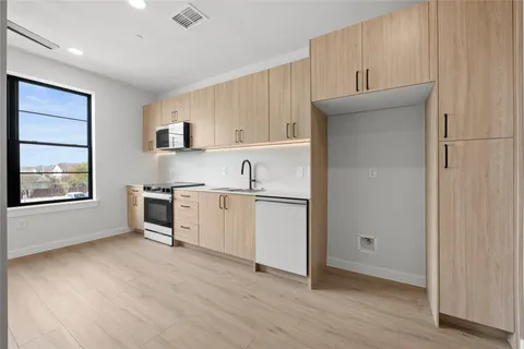 a view of kitchen with wooden floor and electronic appliances