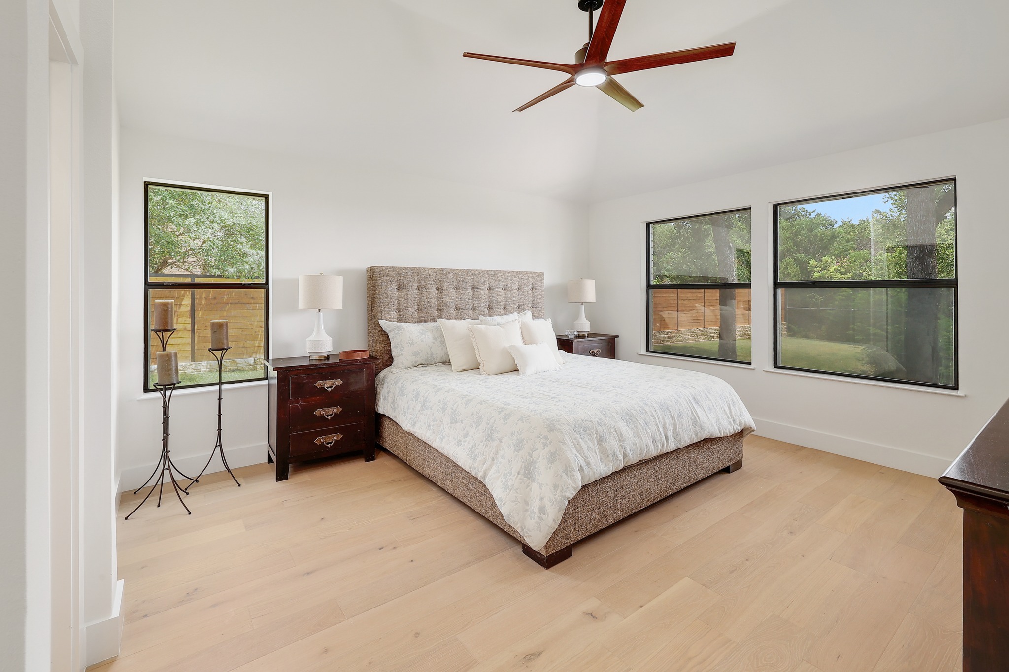 7705 Jester Boulevard Austin, TX 78730 - Photo 13 of 36 Relax in this well-lit primary bedroom featuring a vaulted ceiling and natural wood flooring.