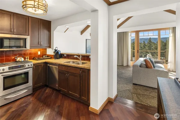 a kitchen with granite countertop a stove sink and cabinets