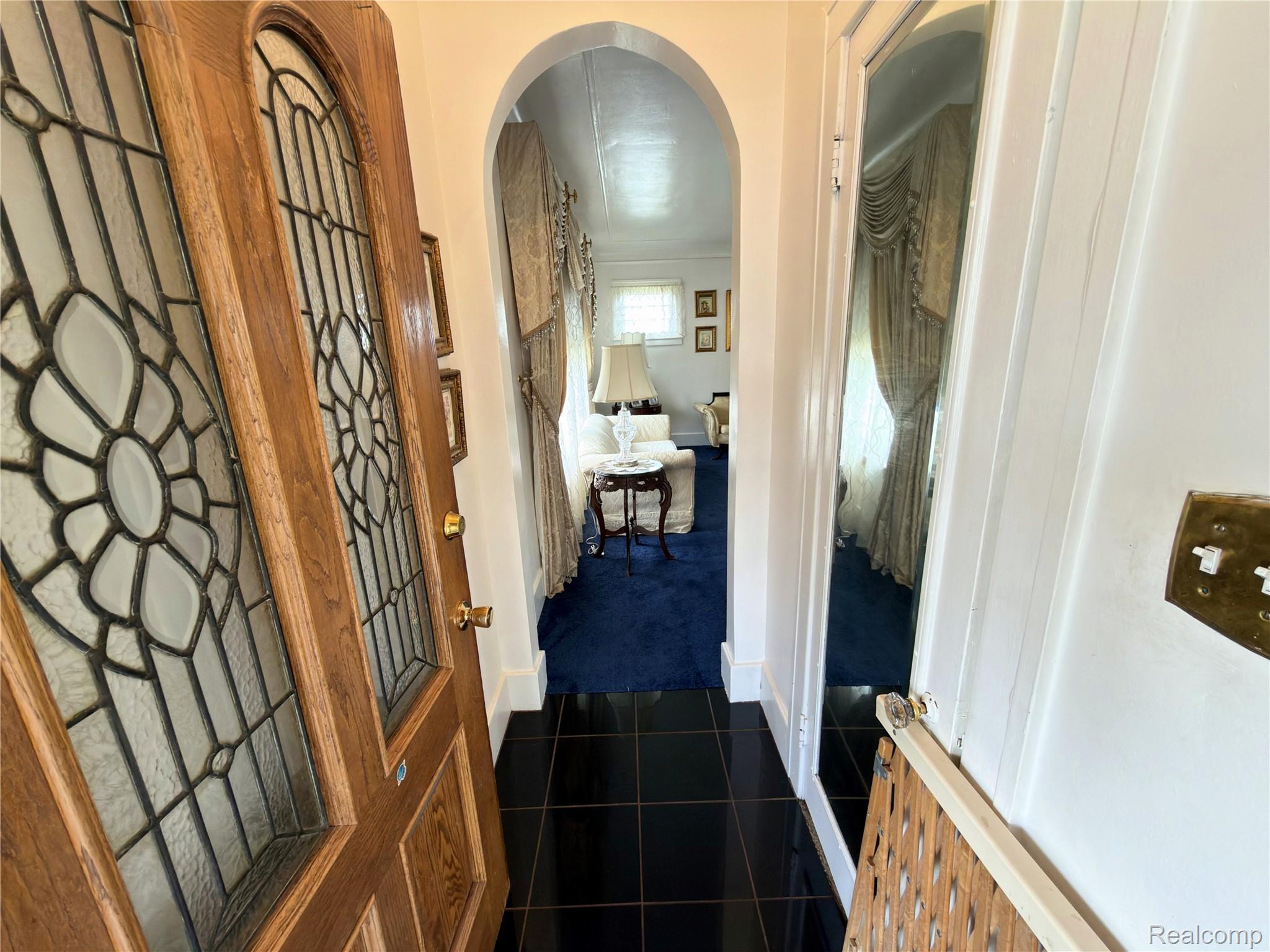 52 Maple Street River Rouge, MI 48218 - Photo 3 of 28 Hallway featuring arched walkways, dark colored carpet, and dark tile patterned flooring
