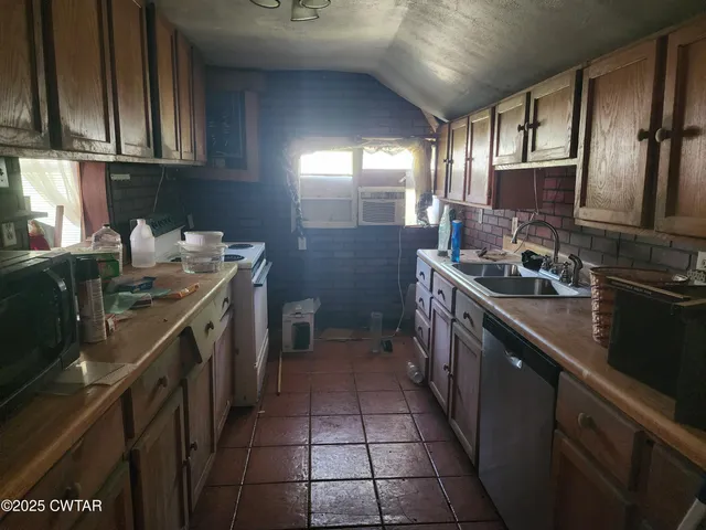 a kitchen with a sink stove top oven and cabinets