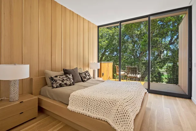 a bedroom with a bed and a large window