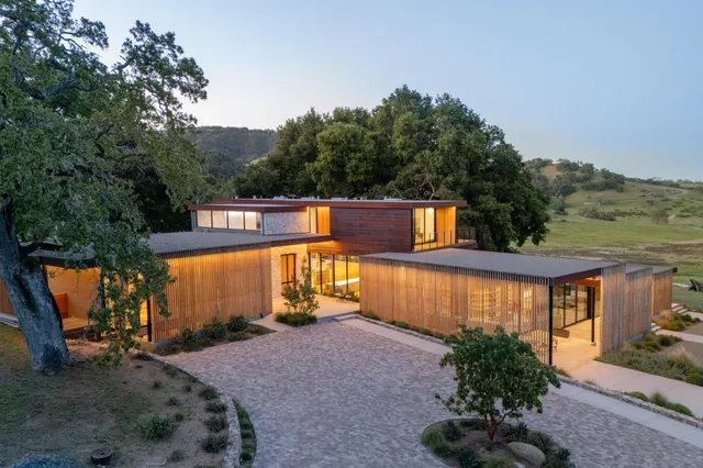 a view of a house with backyard and sitting area