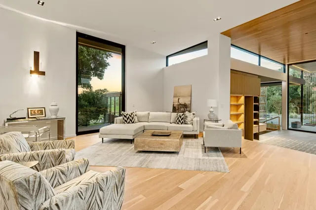 a living room with furniture and floor to ceiling windows