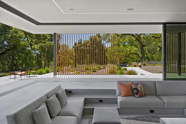 a living room with furniture and a floor to ceiling window