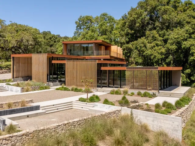 an aerial view of a house with pool and lake view