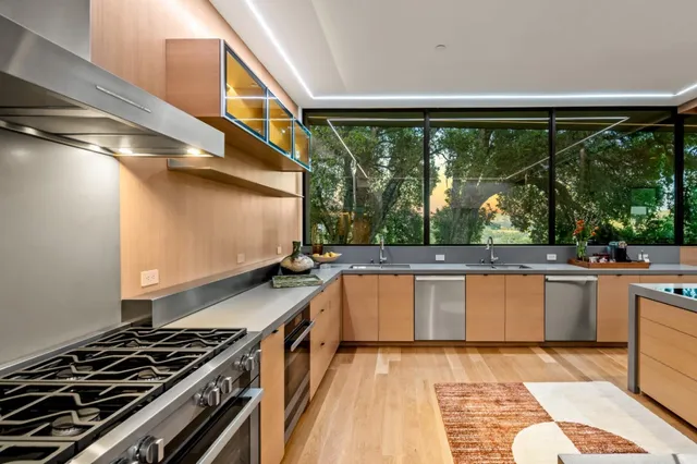 a kitchen with kitchen island a large window in it