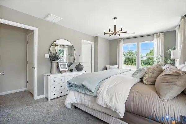 a bedroom with a large bed and a chandelier