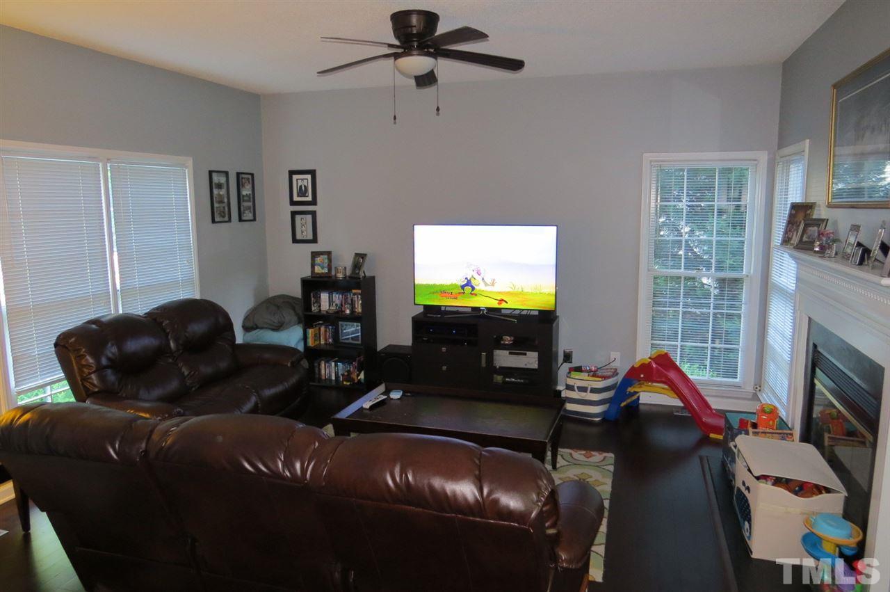 5417 Ingate Way Raleigh, NC 27613 - Photo 6 of 16 a living room with furniture a fireplace and a flat screen tv