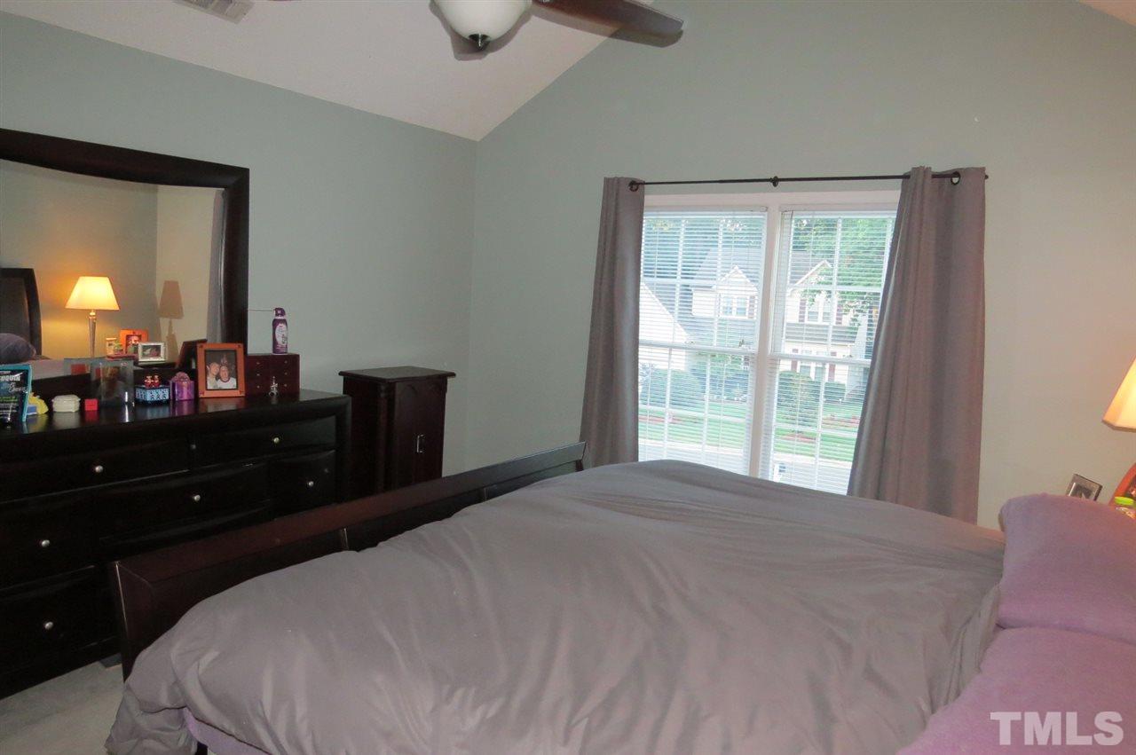 5417 Ingate Way Raleigh, NC 27613 - Photo 8 of 16 a bedroom with a bed and a large mirror