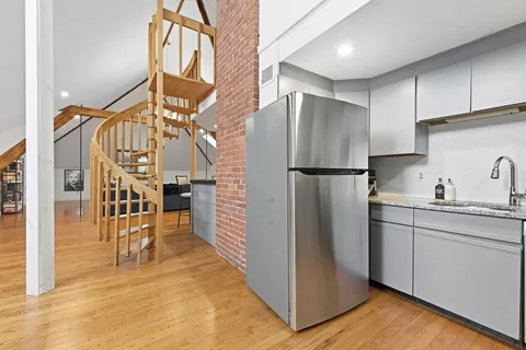 a kitchen with stainless steel appliances granite countertop a refrigerator and a sink