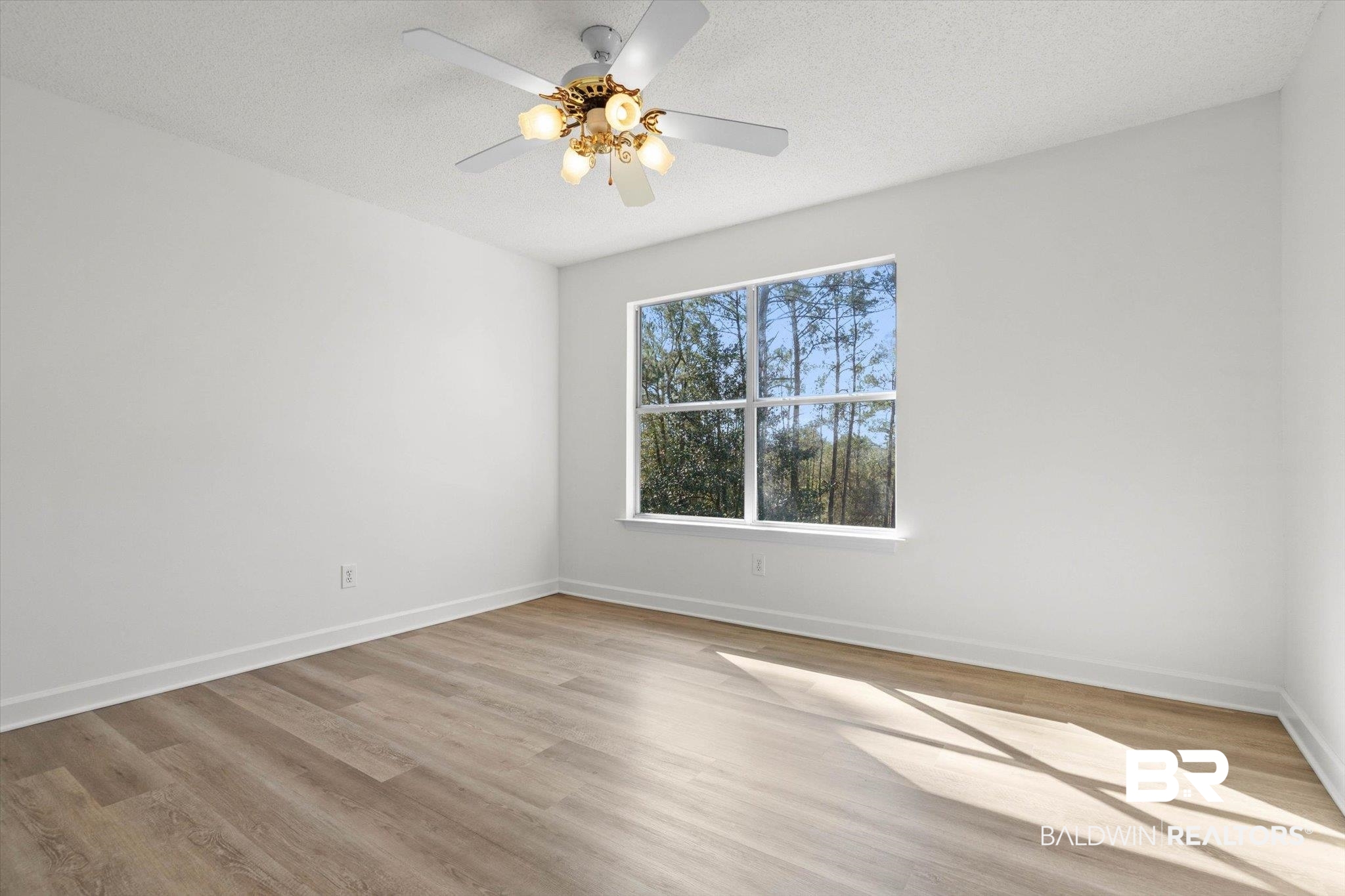 3847 Riviere Du Chien Road Mobile, AL 36693 - Photo 22 of 51 Spare room with light wood-type flooring, ceiling fan, and a textured ceiling