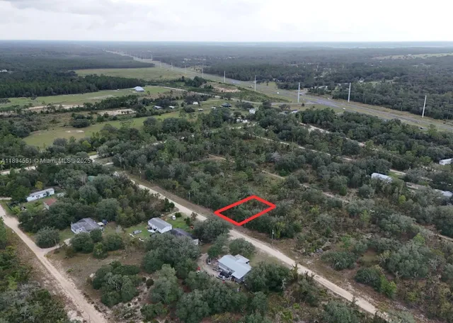 an aerial view of residential houses with outdoor space and trees