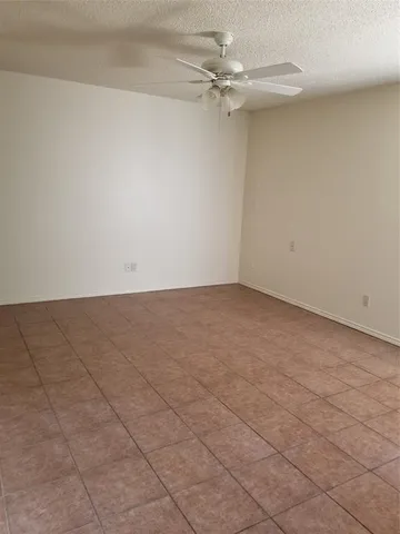 a view of an empty room with a ceiling fan