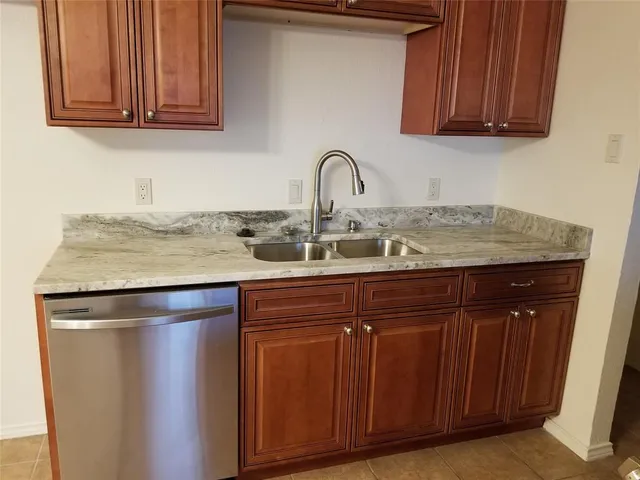 a kitchen with granite countertop wood cabinets and a sink