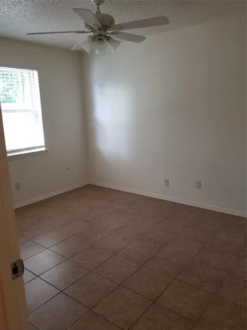 an empty room with a window and a fan