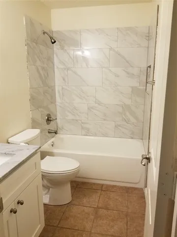 a bathroom with a granite countertop toilet a sink and bathtub