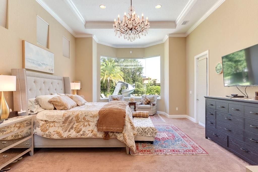 13448 Bellaria Circle Windermere, FL 34786 - Photo 18 of 66 a bedroom with a large bed and a flat tv screen on dresser