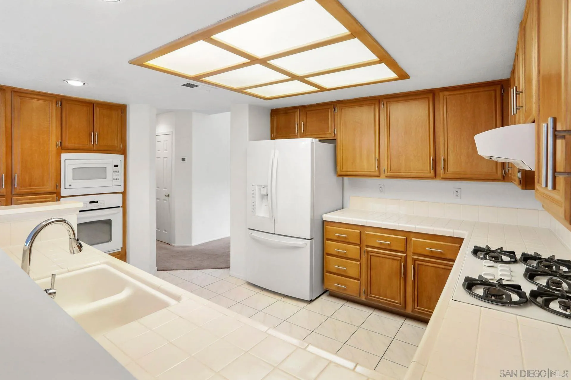 8472 Mesa Heights Road Santee, CA 92071 - Photo 4 of 34 a kitchen with a sink a refrigerator and cabinets
