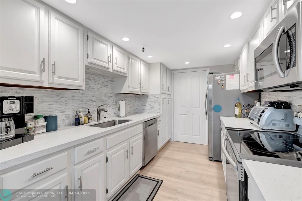 899 Jeffery Street, Unit 109 Boca Raton, FL 33487 - Photo 11 of 37 a kitchen with stainless steel appliances granite countertop a sink stove and cabinets