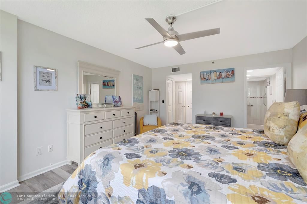 899 Jeffery Street, Unit 109 Boca Raton, FL 33487 - Photo 16 of 37 a bedroom with a large bed and a chandelier